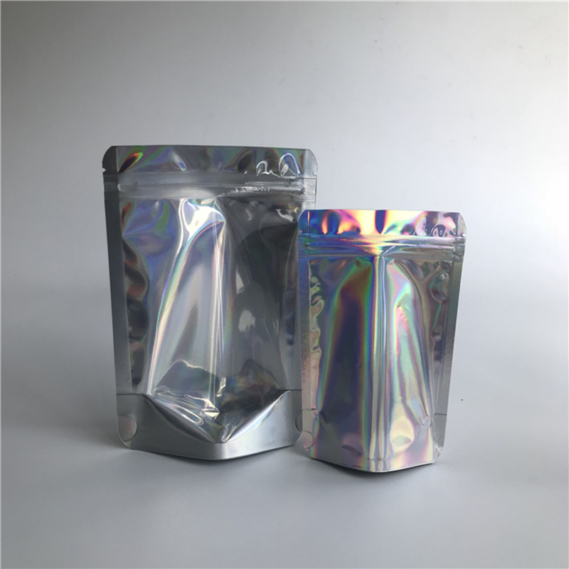 Bolsas de pie holográficas frontales transparentes y sellables al por mayor Bolsas de plástico con cremallera de plástico laminado Embalaje en stock