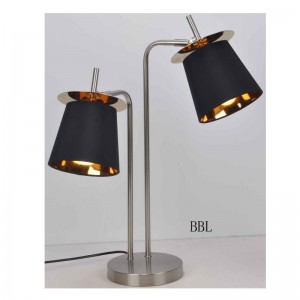 Lámpara de mesa con pantalla de tela y hoja decorativa.